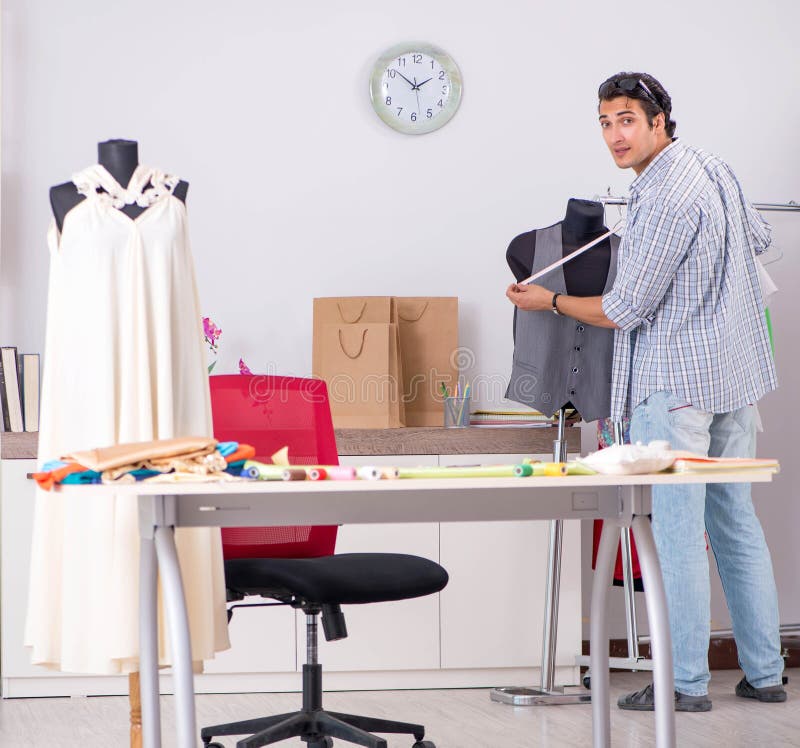 Young handsome tailor working in his workshop stock photos