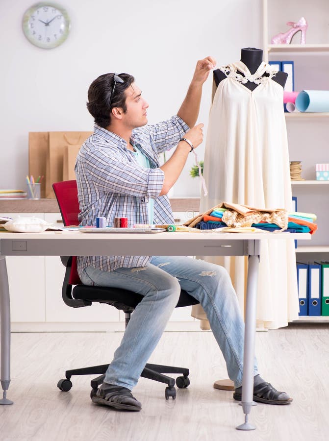 Young handsome tailor working in his workshop royalty free stock photo
