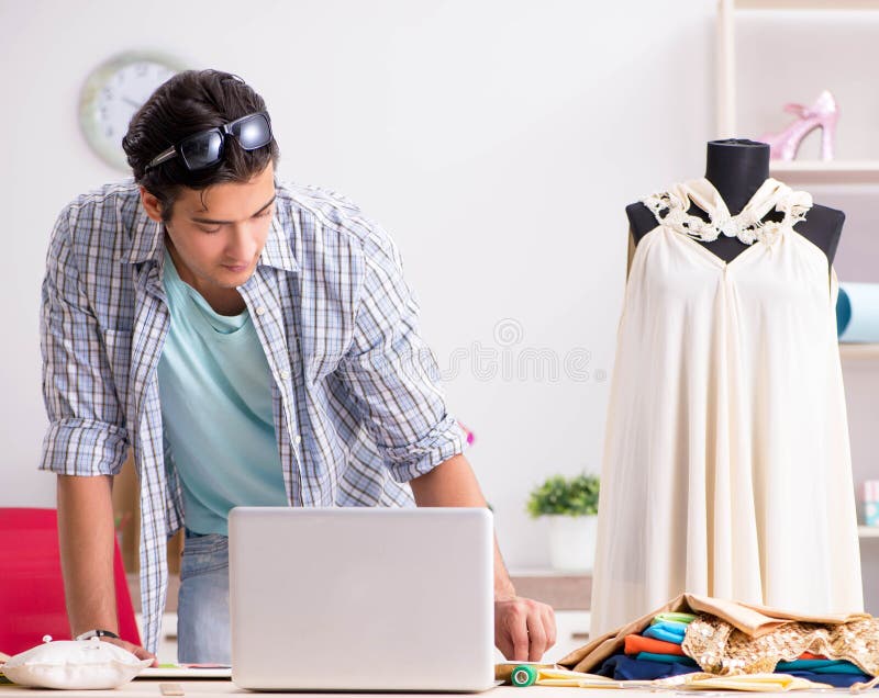Young handsome tailor working in his workshop stock images