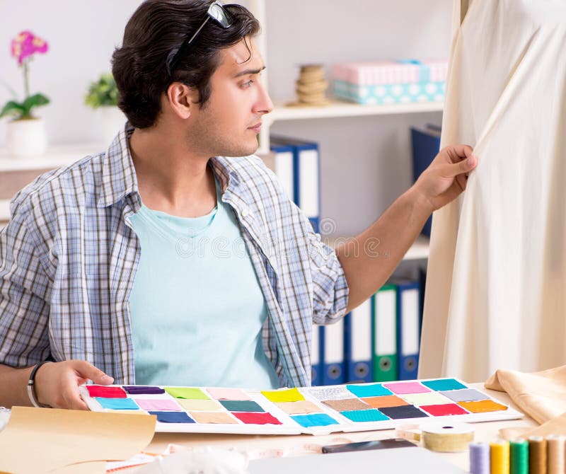 Young handsome tailor working in his workshop royalty free stock image