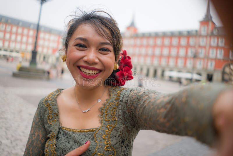 Young Happy And Beautiful Asian Woman Wearing Traditional Balinese Kebaya Dress Taking Selfie