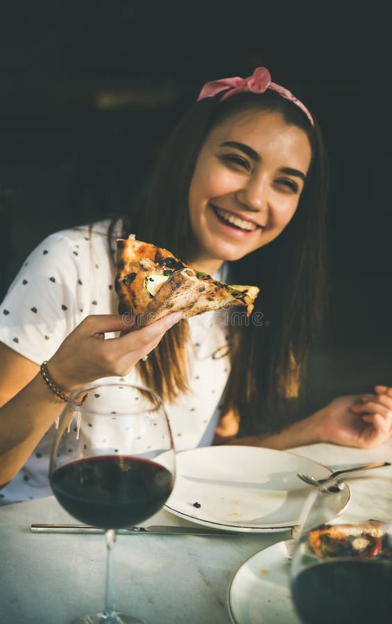 Young happy caucasian woman eating pizza and drinking wine royalty free stock photo Young happy caucasian woman eating pizza and drinking wine royalty free stock photo
