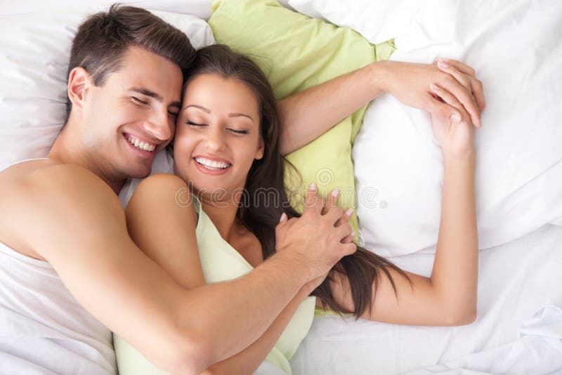 Young happy couple in bed stock photography