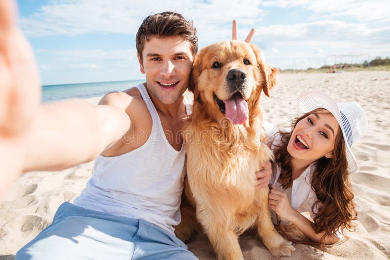 Young happy couple with dog taking a selfie stock photography Young happy couple with dog taking a selfie stock photography