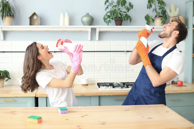 Young happy couple is having fun while doing cleaning and singing at home royalty free stock photos Young happy couple is having fun while doing cleaning and singing at home royalty free stock photos