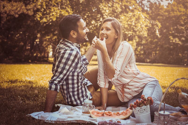 Young Happy Couple Having Picnic in the Meadow. Stock Photo - Image of ...