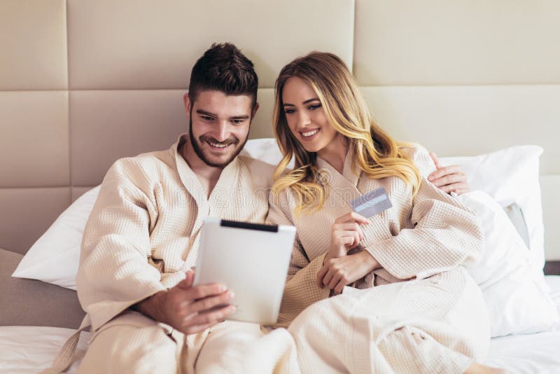 Happy couple shopping online in luxury hotel room royalty free stock photo Happy couple shopping online in luxury hotel room royalty free stock photo
