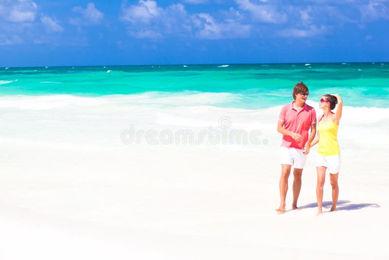 Young happy couple walking on beach smiling. stock photos Young happy couple walking on beach smiling. stock photos