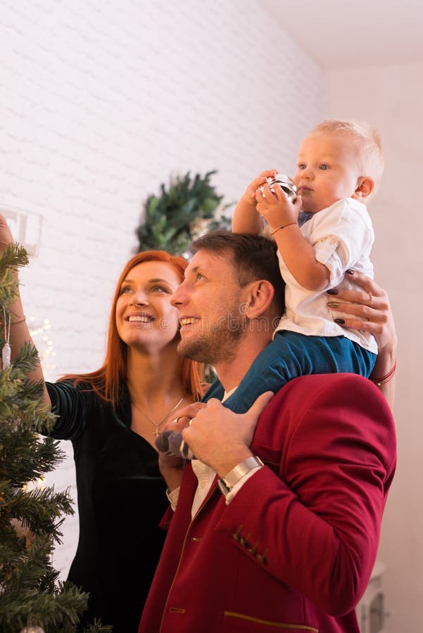 Young Happy Family Dressing Up The Christmas Tree royalty free stock images Young Happy Family Dressing Up The Christmas Tree royalty free stock images