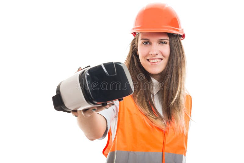 Young happy female builder holding vr headset in hand and smiling