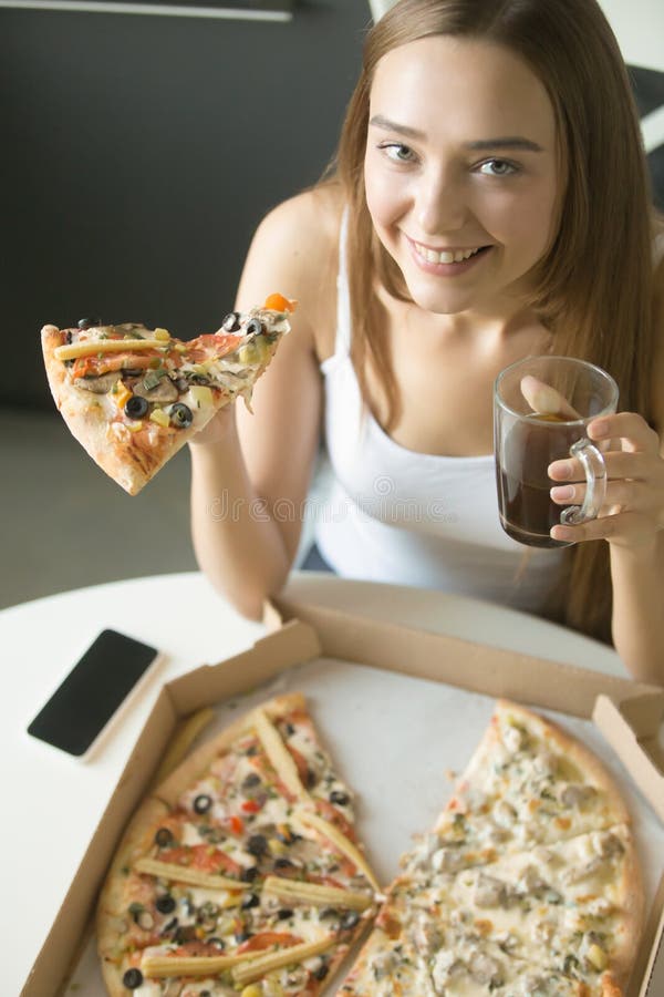 Young happy girl with a slice of pizza stock images Young happy girl with a slice of pizza stock images