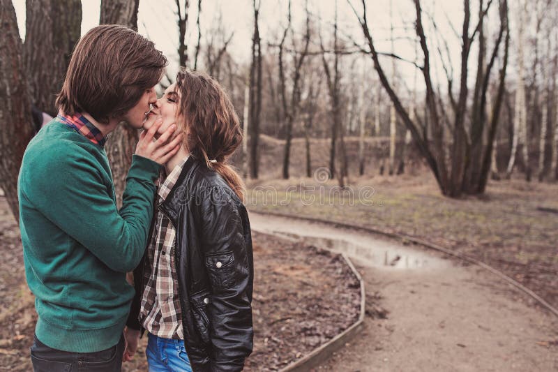 Young happy loving couple kissing on the walk in early spring