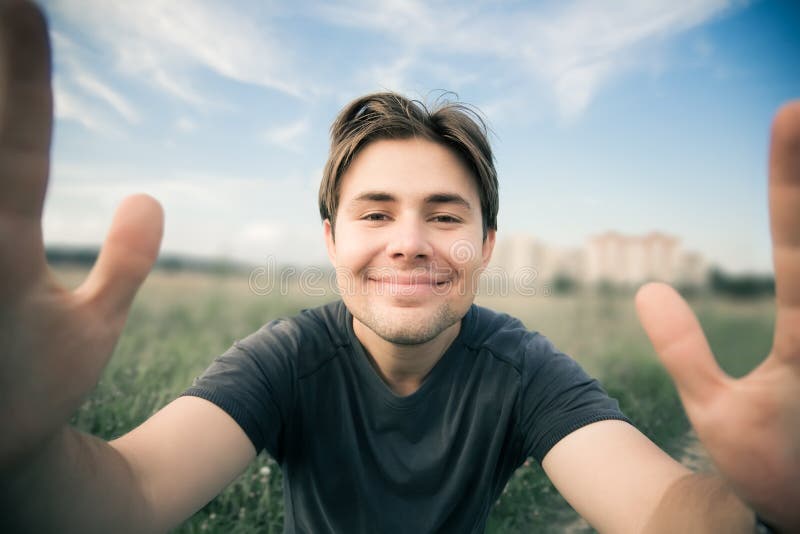 Young happy man stretching to the camera