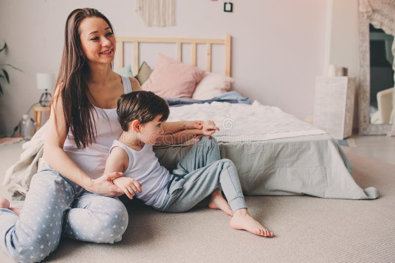 Mother playing with child son in bedroom. Happy family wearing pajamas stock image Mother playing with child son in bedroom. Happy family wearing pajamas stock image