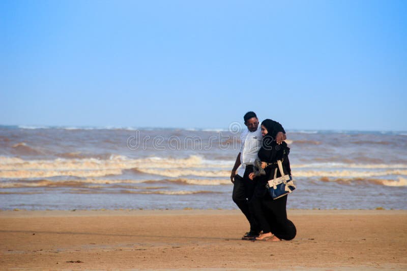 A young happy Muslim black couple are walking along the coast of the Indian Ocean royalty free stock image A young happy Muslim black couple are walking along the coast of the Indian Ocean royalty free stock image