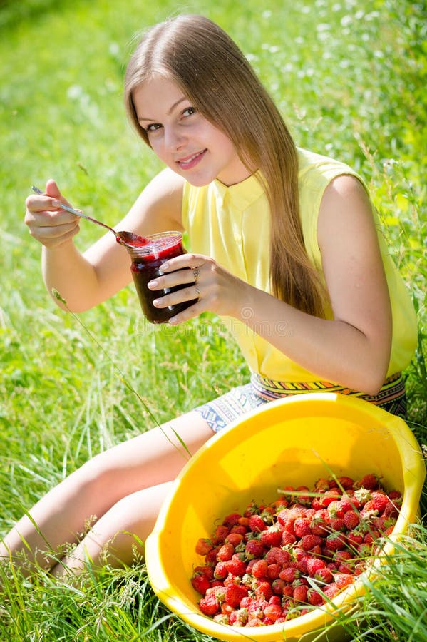 Young happy smiling pretty woman eating jam