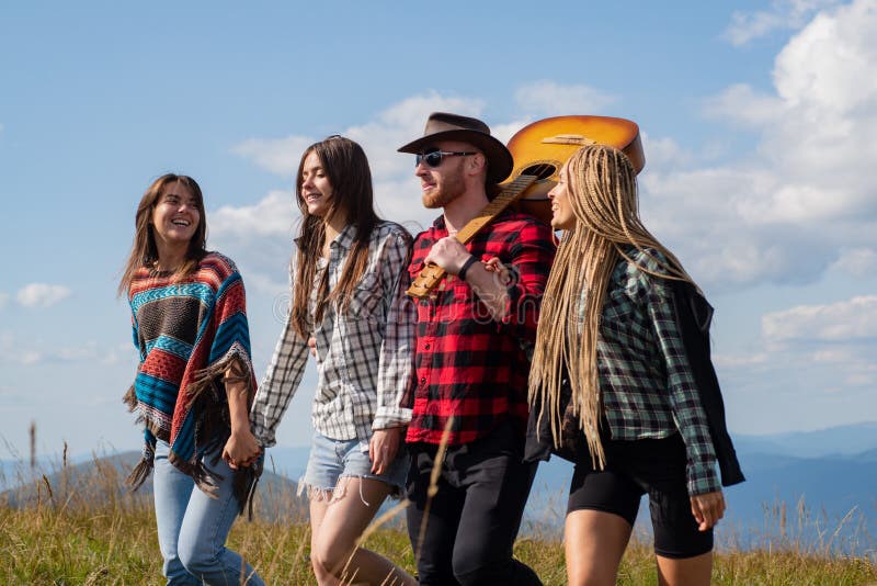 Young happy tourist on mountain enjoying. Happy young friends enjoy a nice day in nature. Group of Friends Camp Forest