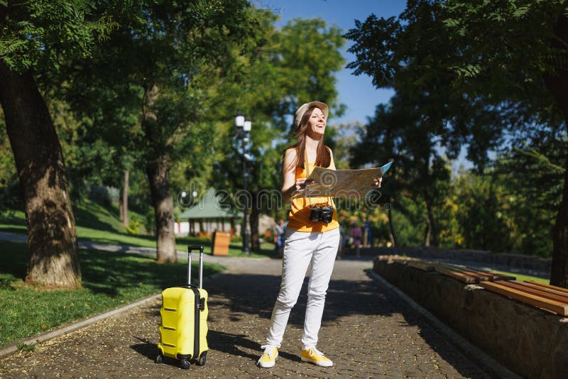 Young happy traveler tourist woman in yellow summer casual clothes, hat with suitcase city map walk in city outdoor royalty free stock photo Young happy traveler tourist woman in yellow summer casual clothes, hat with suitcase city map walk in city outdoor royalty free stock photo