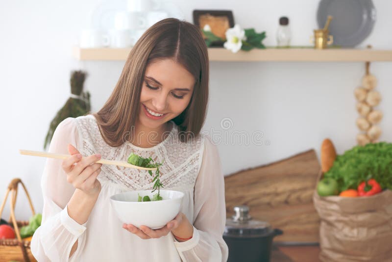 Young happy woman cooking in the kitchen. Healthy meal, lifestyle and culinary concept stock image Young happy woman cooking in the kitchen. Healthy meal, lifestyle and culinary concept stock image
