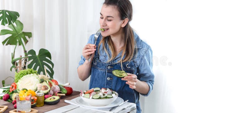 Young and happy woman eating salad at the table stock photos Young and happy woman eating salad at the table stock photos