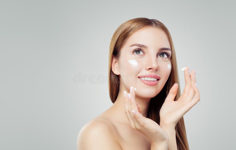 Young happy woman with healthy skin applying cosmetic cream. Skincare, beauty and facial treatment concept royalty free stock images Young happy woman with healthy skin applying cosmetic cream. Skincare, beauty and facial treatment concept royalty free stock images