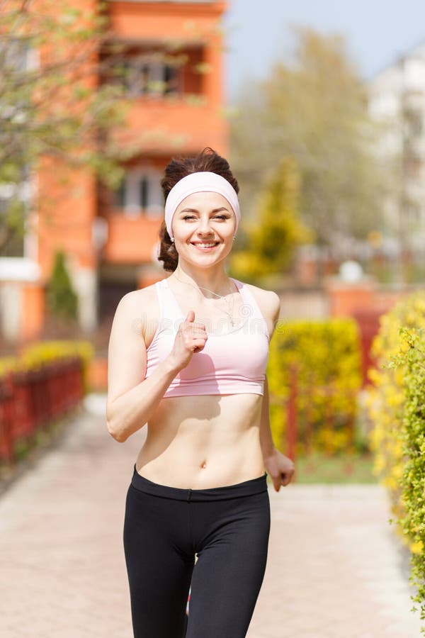 Young happy woman jogging in the street royalty free stock images Young happy woman jogging in the street royalty free stock images