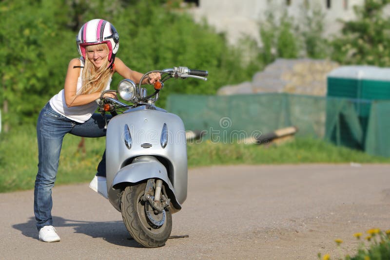 Young happy woman on scooter outdoor