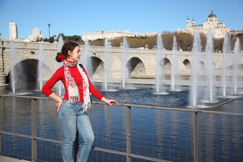 Young happy woman stands near bridge