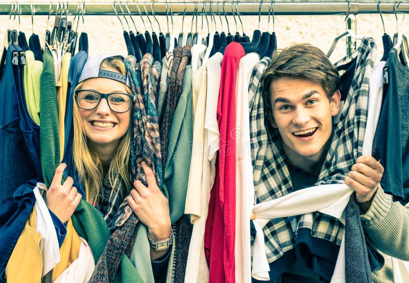 Young hipster couple in love at the weekly cloth market - Best friends sharing free time having fun and shopping in the old town - Lovers enjoying everyday life moments on a vintage filtered look