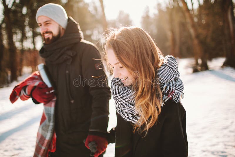 Young hipster couple walking in winter forest holding hands stock photography Young hipster couple walking in winter forest holding hands stock photography