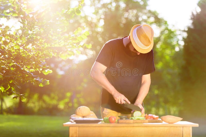 Young hipster man preparing food for garden grill party, summer barbecue royalty free stock images Young hipster man preparing food for garden grill party, summer barbecue royalty free stock images