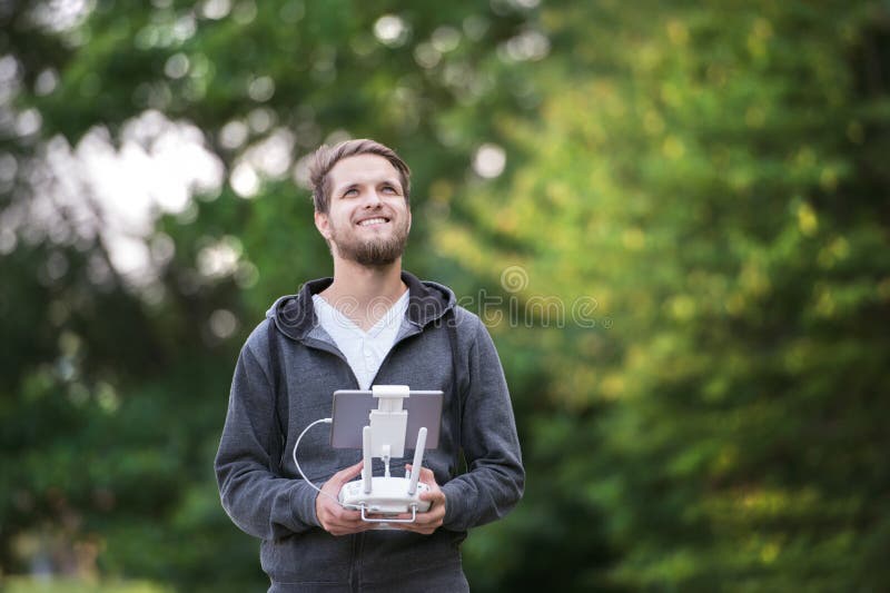 Young hipster man with remote control. Sunny green nature. royalty free stock image
