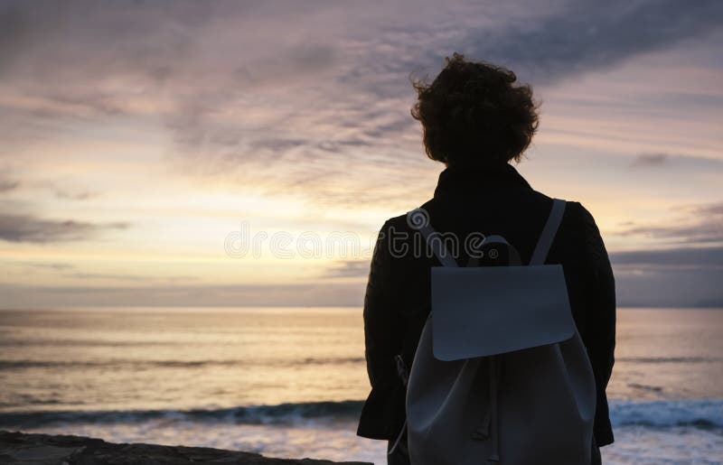 Young hipster relax on the beach on background ocean sunrise, silhouette romantic person looking view evening seascape, girl enjoy stock image Young hipster relax on the beach on background ocean sunrise, silhouette romantic person looking view evening seascape, girl enjoy stock image