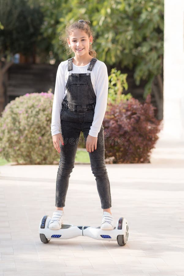 Young hipster teenager girl balancing on electric Hover Board, Dual Wheel Self Balancing Electric Skateboard sunny park. royalty free stock image Young hipster teenager girl balancing on electric Hover Board, Dual Wheel Self Balancing Electric Skateboard sunny park. royalty free stock image