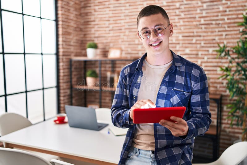 Young hispanic man using touchpad standing at home stock image