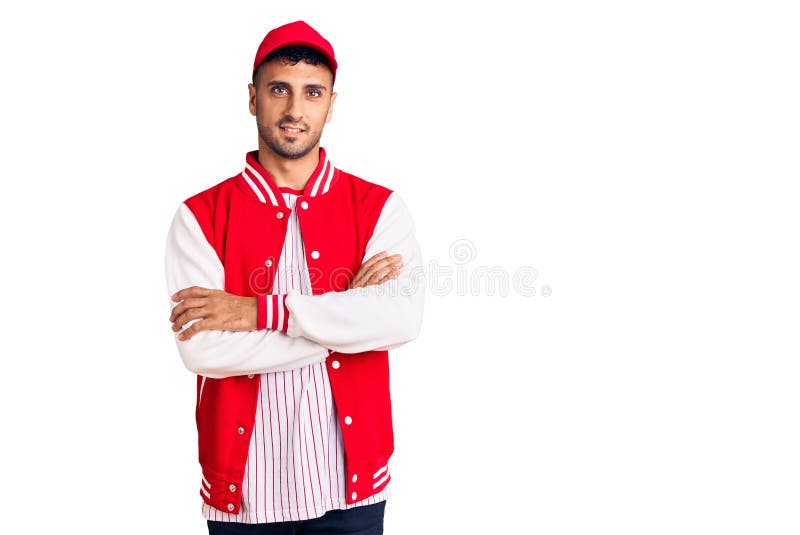 Young hispanic man wearing baseball uniform happy face smiling with crossed arms looking at the camera