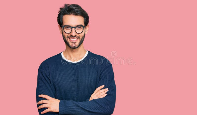 Young hispanic man wearing casual clothes and glasses happy face smiling with crossed arms looking at the camera