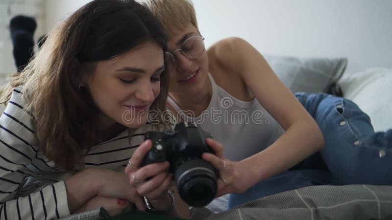 Young Homosexual Couple of Girls is Using Camera, Lying on Bed in Home Bedroom Spbd. Stock Footage - Video of glasses, device: 182682138