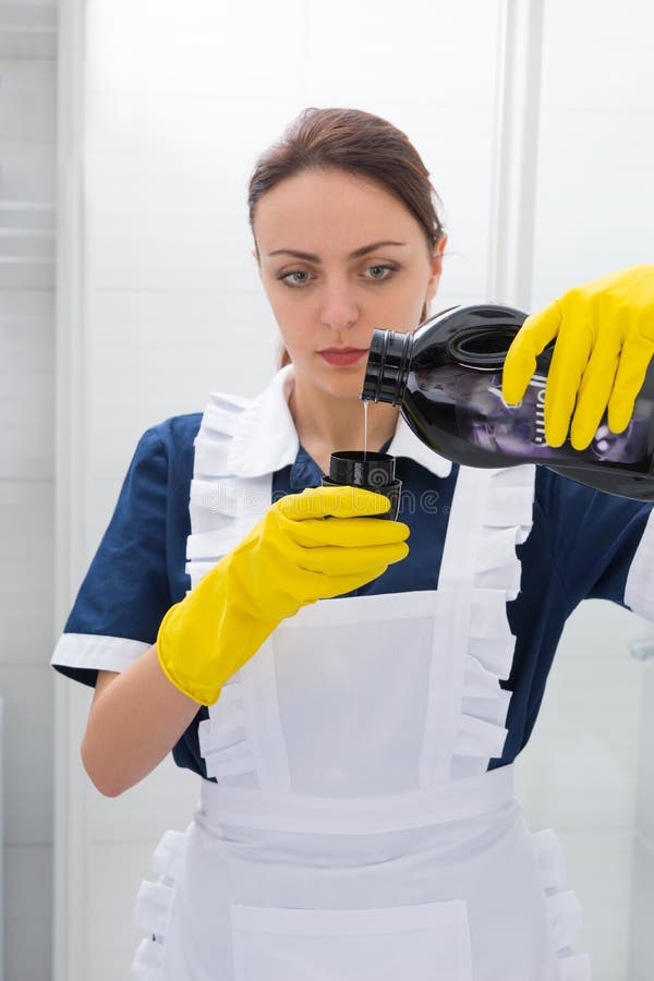 Young housekeeper pouring out detergent royalty free stock photography Young housekeeper pouring out detergent royalty free stock photography