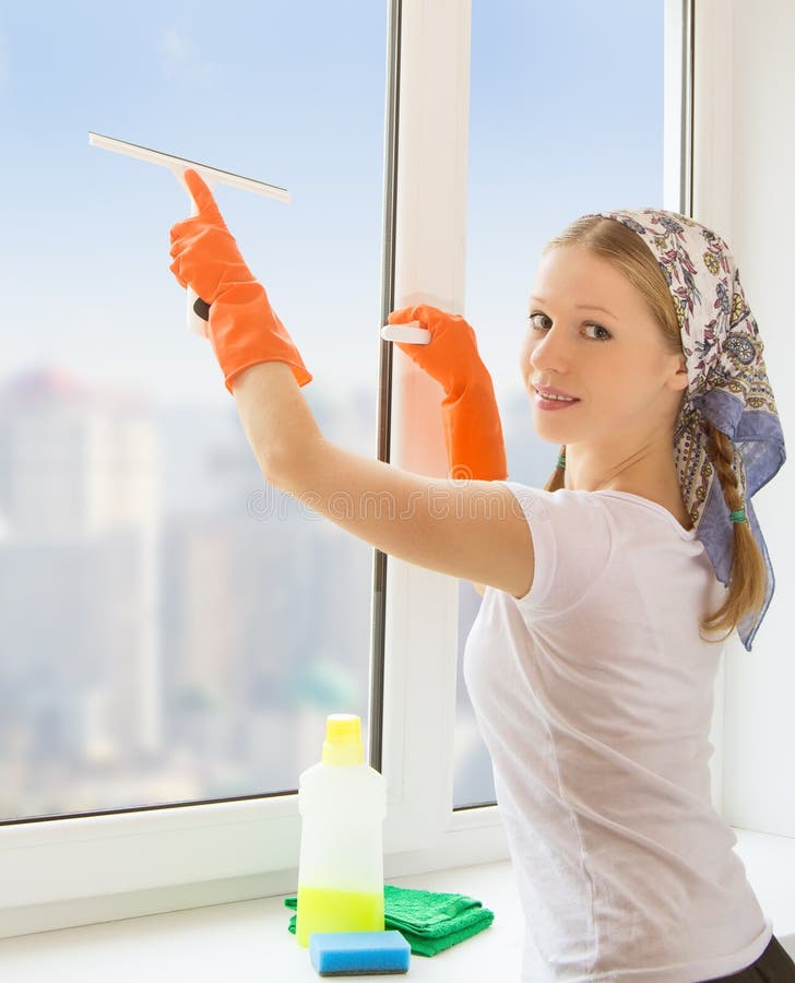 Young housewife washing the window