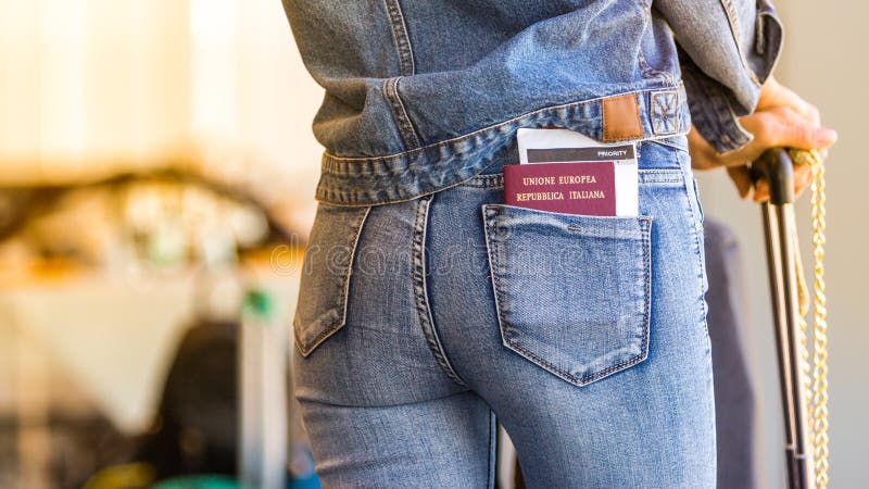 A young independent woman alone is waiting for her departure with a passport and boarding pass in the back pocket