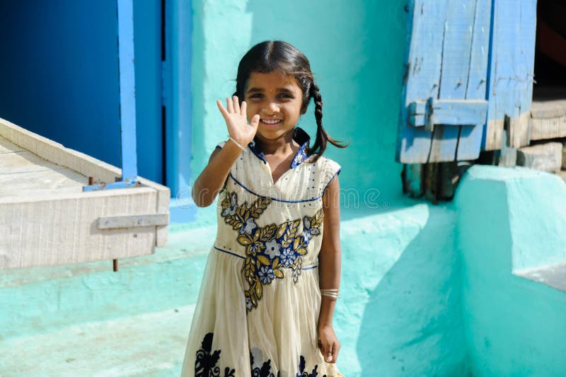 Young indian girl smiling and waving by hand in camera in outdoors 11 february 2018 Puttaparthi, India