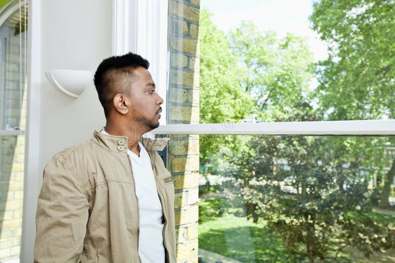 Young Indian man looking out window