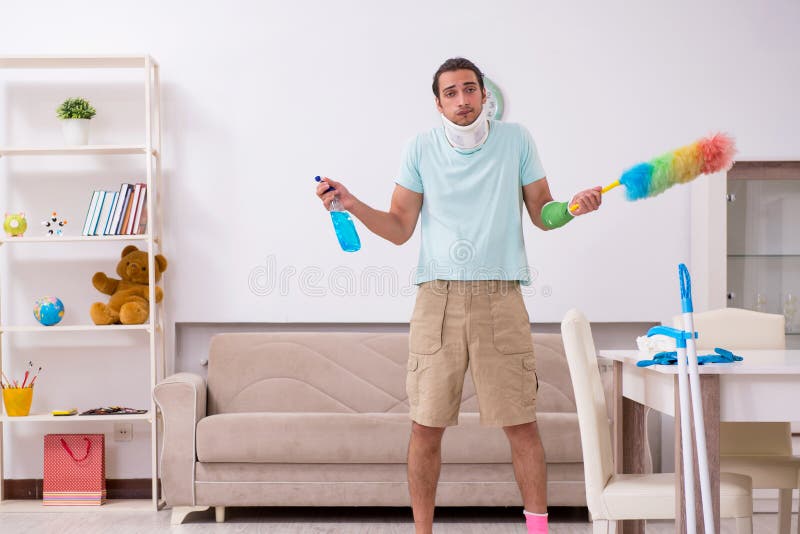 Young injured man cleaning the house. 