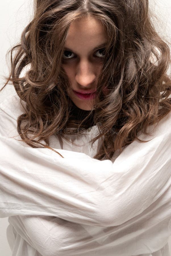 Young insane woman with straitjacket looking