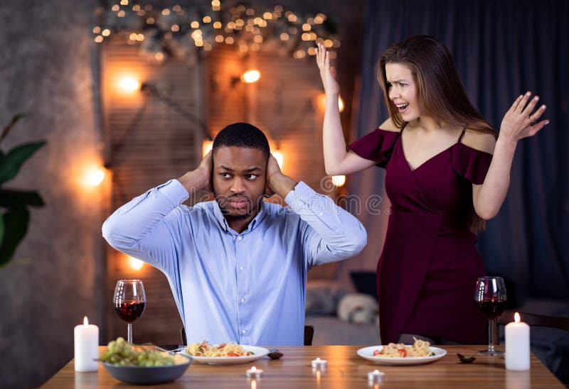 Young Interracial Couple Arguing During Dinner Date In Restaurant