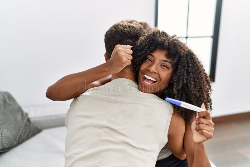 Young Interracial Couple Holding Pregnancy Test Result Screaming Proud