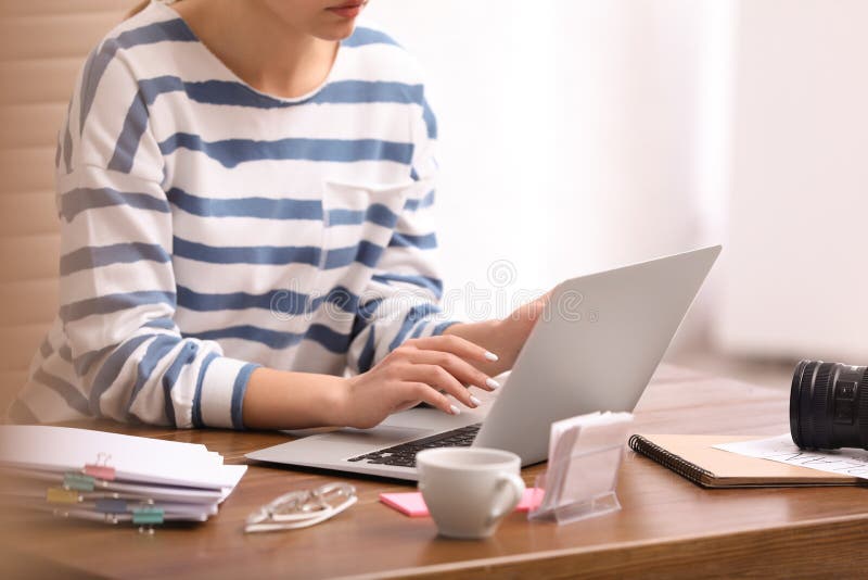 Young journalist working with laptop in office stock photography