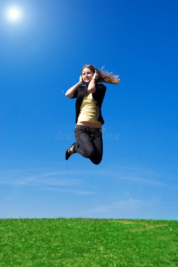The young jumping girl with headphones