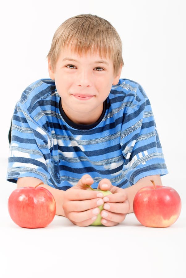 Young kid laying on the floor and 3 apples